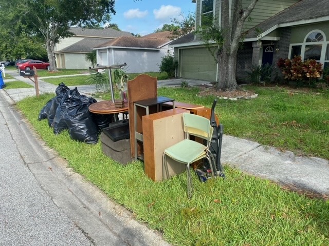 Curbside furniture and bagged trash awaiting pickup